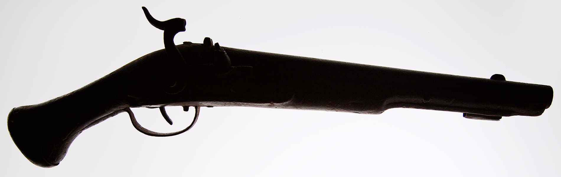 En gammal pistol mot vit bakgrund