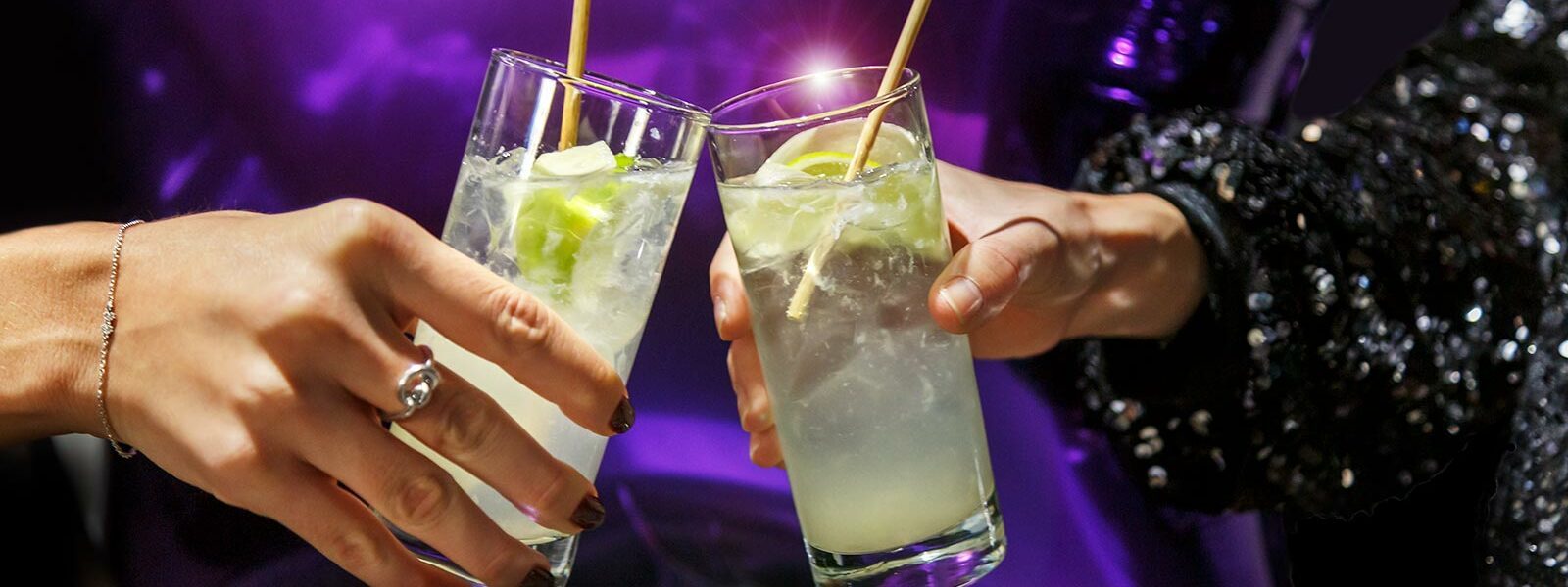 två händer som skålar med varsin drink