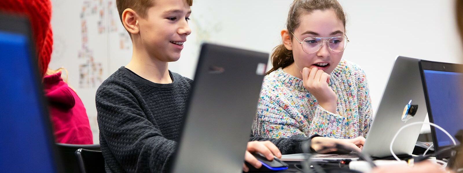 tjej och kille som sitter framför datorn och programmerar