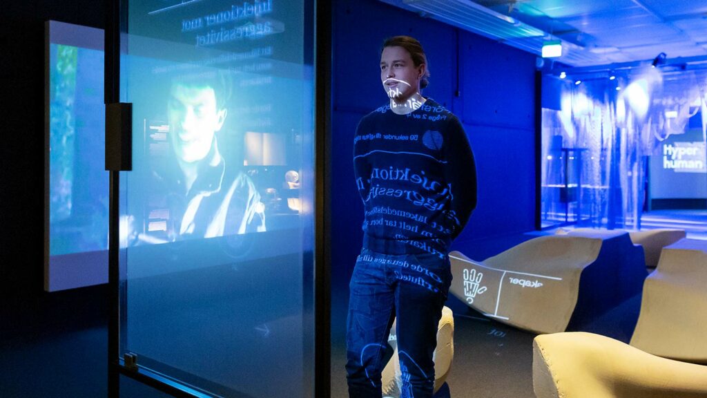 Kille tittar på digital skärm i utställningen hyper human