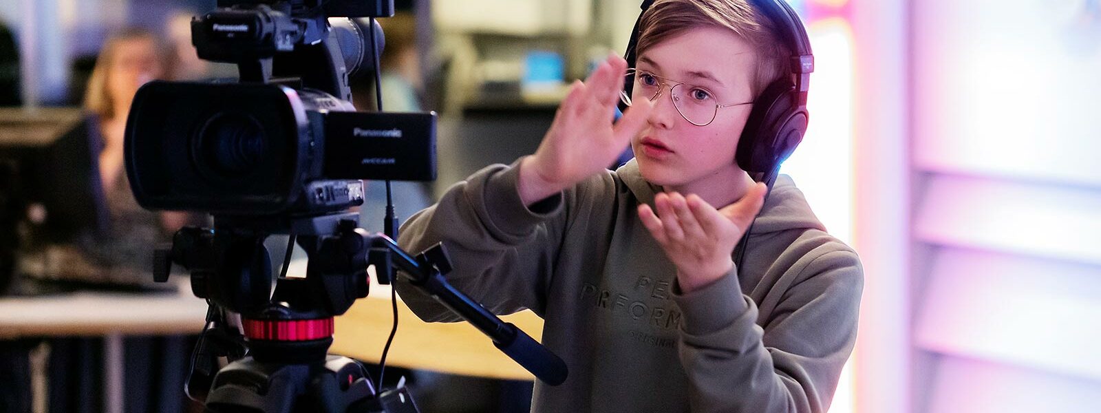 pojke som klappar med händerna och står bakom kameran i Tekniska museets studio.
