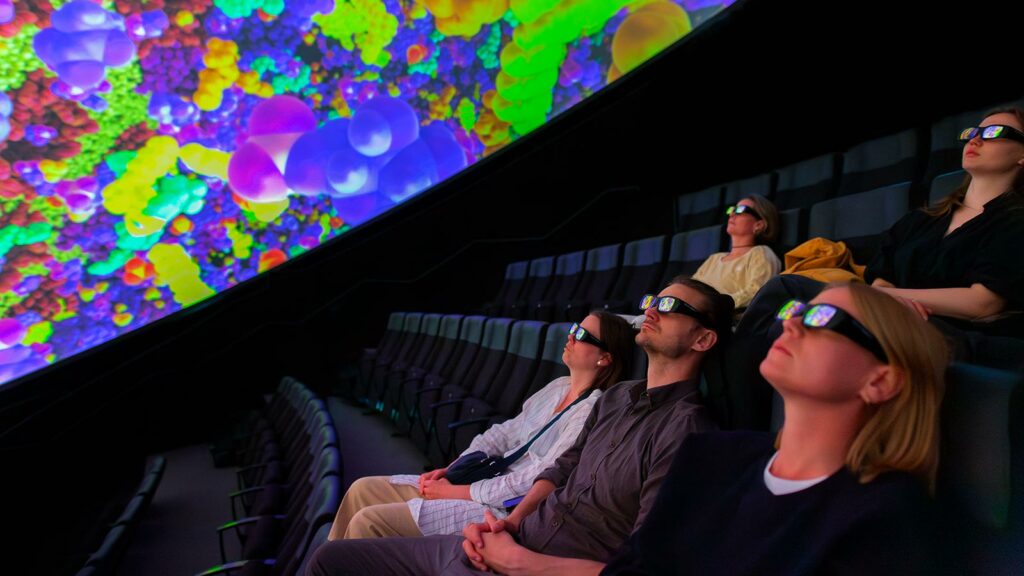 personer med vr-glasogön sitter och tittar på en domeföreställning i wisdome stockholm