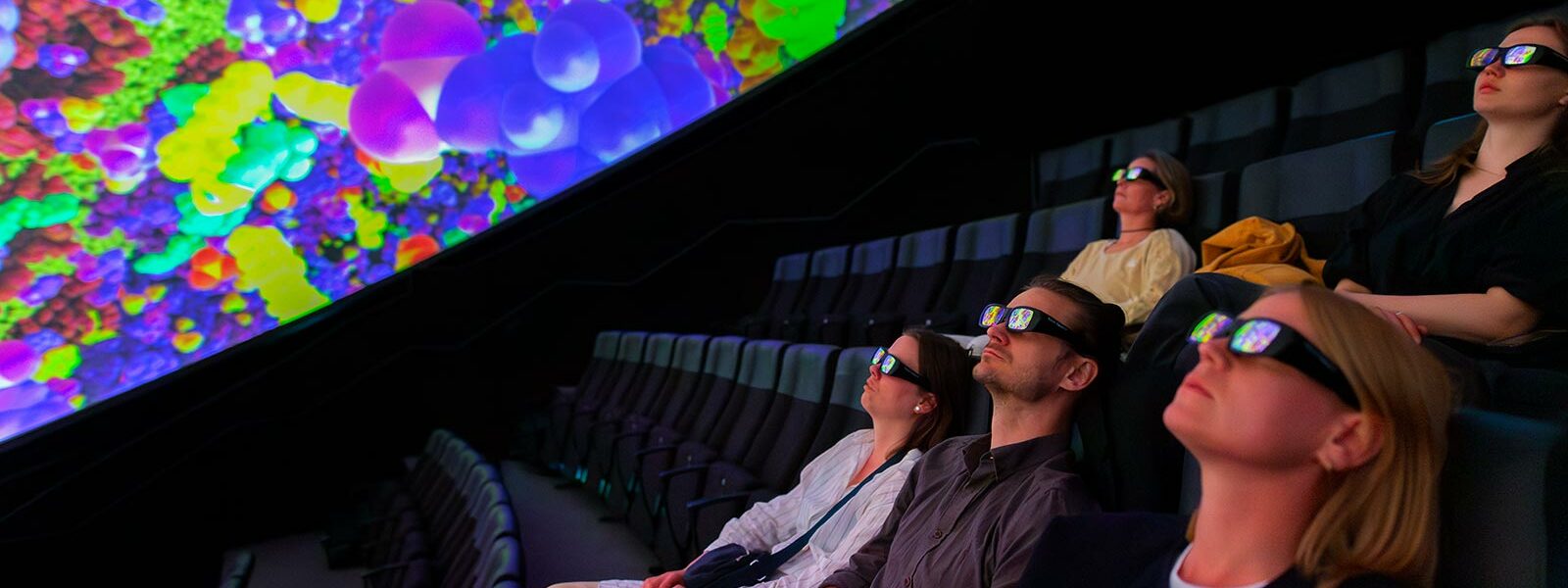personer med vr-glasogön sitter och tittar på en domeföreställning i wisdome stockholm