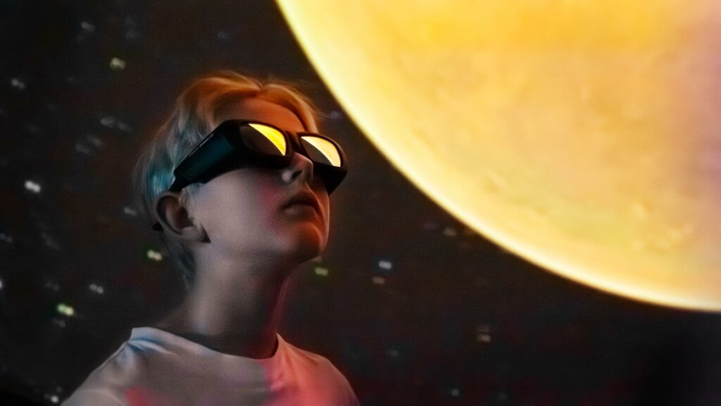 Pojke med VR-glasögon tittar på en föreställning i en dome, Wisdome Stockholm.